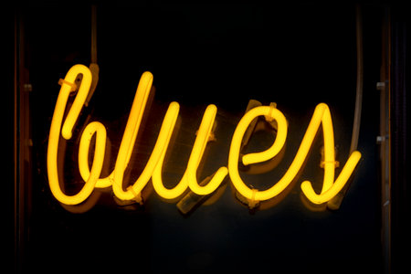Yellow neon light shaped into the word "Blues".の写真素材