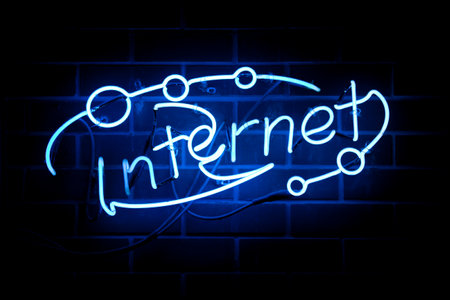 Blue indoor neon light shaped into the word 'Internet'.の写真素材