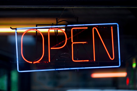 Close-up on a neon light shaped into a blue rectangle and the word "open" in red.の写真素材