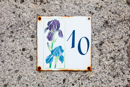 Close-up on an enameled plaque with the Number 10 on a stone wall.の写真素材