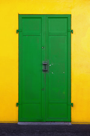 Old house with a yellow wall with a green door in Saint-Denis, Reunion Island.の写真素材