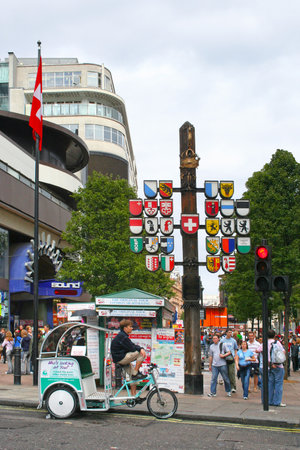 London, England - August 19 2006: People walking through Swiss Court, part of Leicester Square in Central London. Leicester Square is at the heart of Londonâs entertainment district, with several cinemas and other places of interest. At the entrance of のeditorial素材