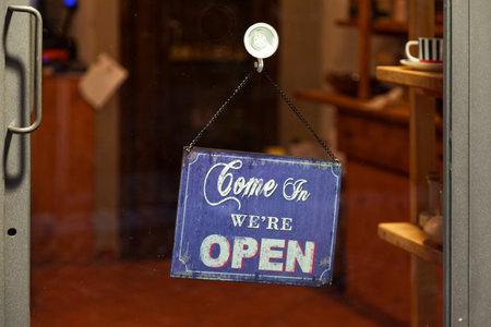 Open sign with written in it: "Come in, we're open".の写真素材