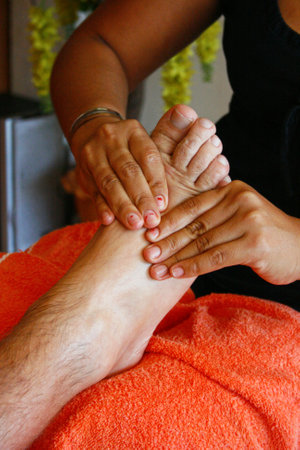Woman doing a Foot massage to a tourist in Pattaya, Thailand.の写真素材