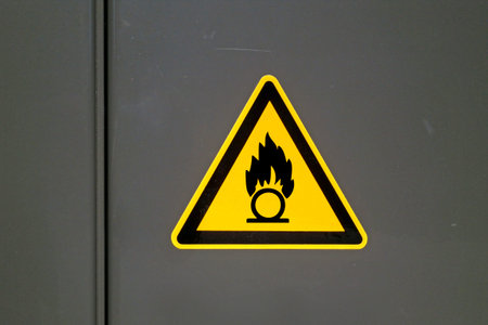 Yellow caution sign on a metal door warning about "Self ignition".の写真素材