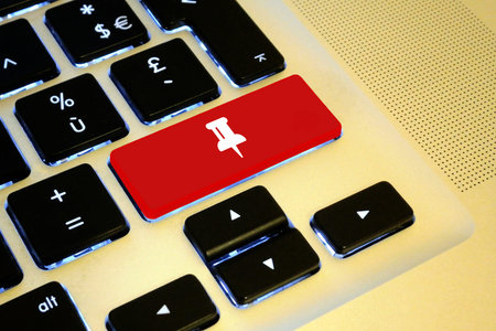Close up on a red key with a white Push-pin on it.