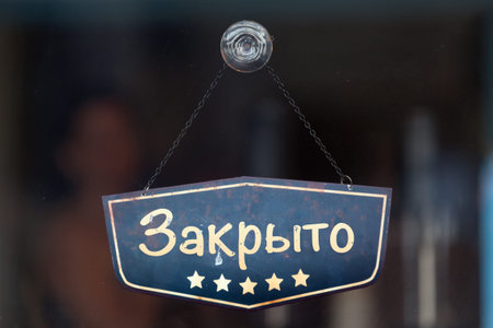 Old fashioned sign in the window of a shop saying in Russian Ð—Ð°ÐºÑ€Ñ‹Ñ‚Ð¾,...