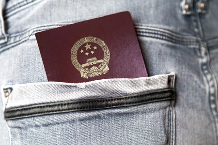 Close-up on a Chinese passport in a jean's back pocket