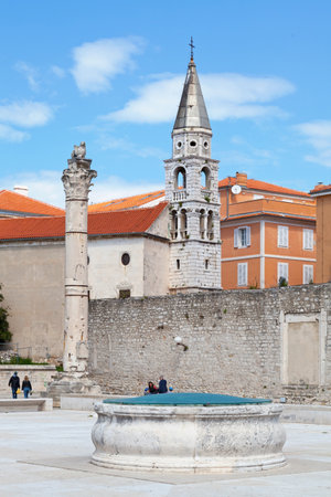 Zadar, Croatia, April 15 2019: Former wheel in the middle of the Pope John Paul II's Field (Poljana Pape Ivana Pavla II) opposite the Pillar of shame (Stup srama) and the Eastern Orthodox Church of Saint Elias (Sveti Ilija).のeditorial素材