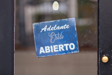 Open sign with written in it in Spanish: Adelante, estÃ¡ abierto, meaning in English Come in, it's...