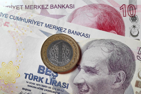 Close-up on a coin on top of a banknote of 5 an 10 Turkish lira (TRY).の写真素材