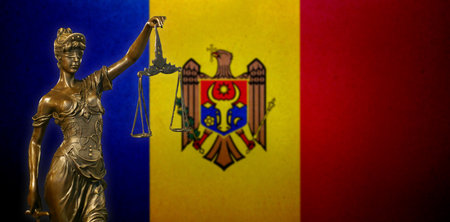 Close-up of a small bronze statuette of Lady Justice before a flag of Moldova.の写真素材