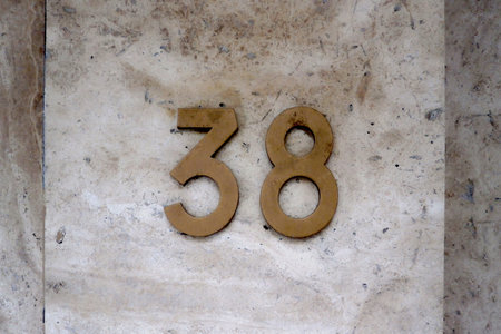 Close-up on a Number 38 on a marble wall.