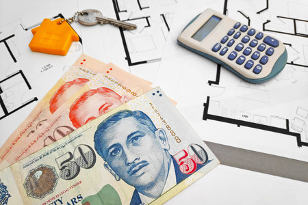 Close-up on some Singaporean Dollar banknotes, a home key and a calculator on the top of building...