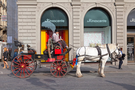 Florence, Italy - April 01 2019: Coach driver on his carriage waiting for tourists in the city...