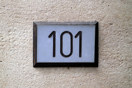 Close-up on a street plate with the number 101 in the middle.