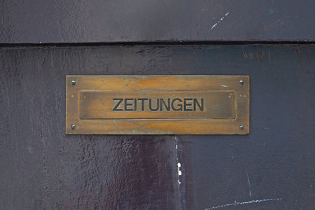Close-up on a mail slot with written in German "Zeitungen", meaning "Newspapers" in English.の写真素材