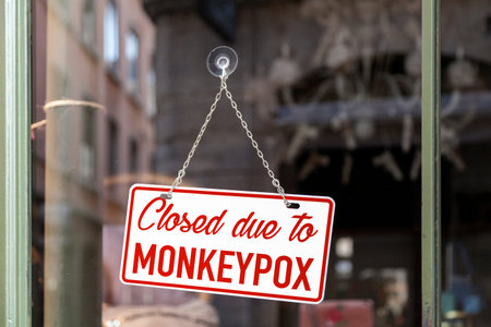 Close-up on a red and white sign in a window with written in it "Closed due to monkeypox".の写真素材
