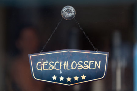 Old fashioned sign in the window of a shop saying in German "Geschlossen", meaning in english "Closed".の写真素材