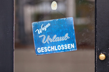 Red open sign with written in German "Wegen Urlaub geschlossen" meaning in English "Closure for holidays".の写真素材