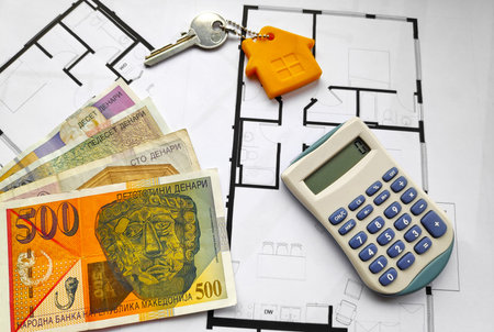 Close-up on some Macedonian denar banknotes, a home key and a calculator on the top of building...