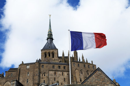 View of the Mont-Saint-Michel Abbey with a french flagの写真素材