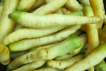 Close-up on a stack of yellow carrots on a market stall.の写真素材