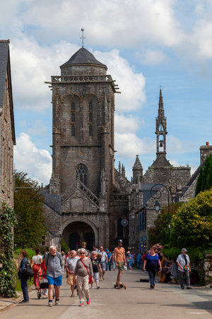 Locronan, France - August 17 2023: 15th century church of Saint-Ronan dwarfing the rest of the town.のeditorial素材