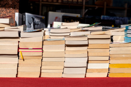 Stacks of used books for sale displayed on a stall.の写真素材