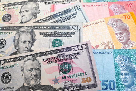 Close-up on a stack of US Dollar and Malaysian ringgit.