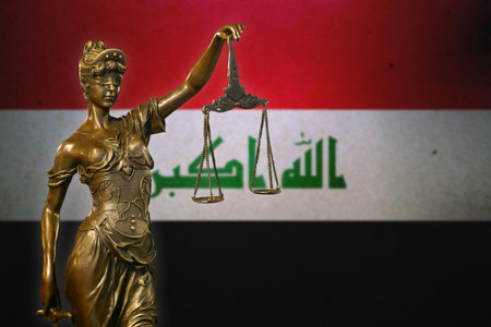 Close-up of a small bronze statuette of Lady Justice before a flag of Iraq.の写真素材