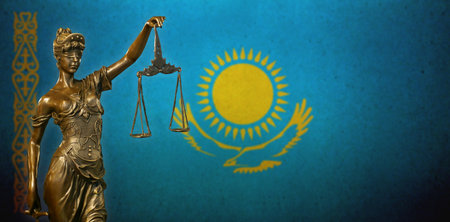 Close-up of a small bronze statuette of Lady Justice before a flag of Kazakhstan.の写真素材