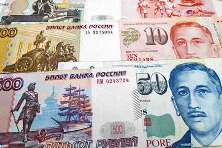 Close-up on a stack of Russian Rubles and Singaporean Dollars.