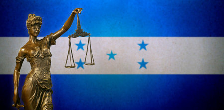 Close-up of a small bronze statuette of Lady Justice before a Hondurian flag.の写真素材