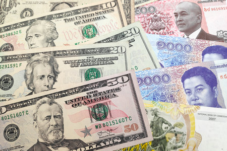 Close-up on a stack of US Dollar and Cambodian riel.の写真素材
