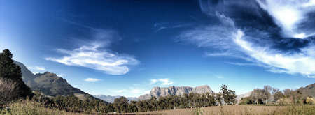 A mountain in the background with vineyards and dramatic sky. Cape Town. の素材