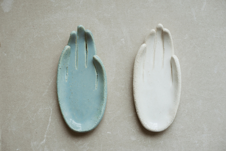 Top view on chamotte clay blue and white hands for holding rings and little things on grey industrial tableの写真素材