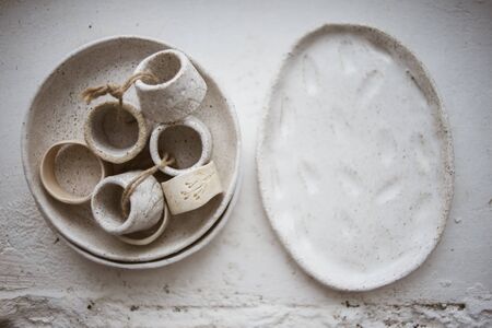 Top view on two grog clay plates with beautiful rustic napkin rings on white backgroundの写真素材