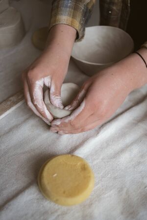 Woman's hands makes clay ware in pottery workshopの写真素材
