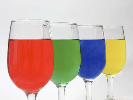 Photo of four glasses with a different colored liquid in eachの写真素材