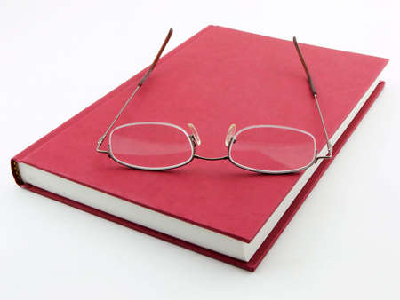 Photo of a book with a pair of glasses on itの写真素材