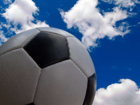Photo of a soccer ball set against cloudy sky backgroundの写真素材