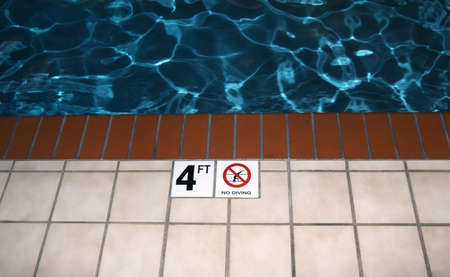 Photo of a no diving symbol next to a poolの写真素材