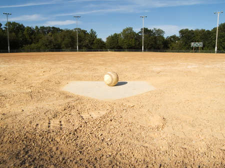 Home plate on a baseball field with a baseball set on itの写真素材