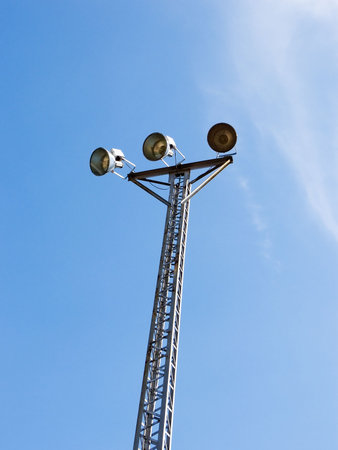 Set of three flood lights against a sky background