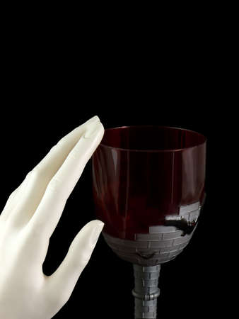 Vampire goblet with hand rubbing the rim, isolated on blackの写真素材