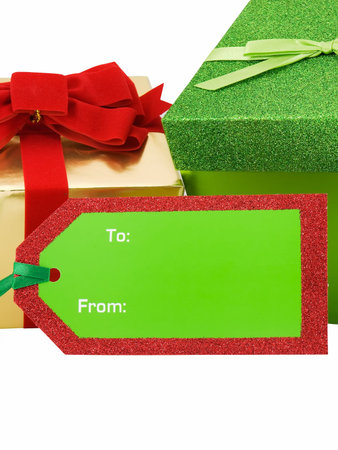 Christmas gift tag in front of presents isolated on whiteの写真素材