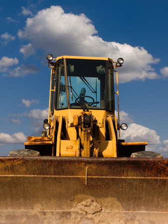 Bulldozer from the front with cloudy sky background
