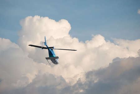 Helicopter flying off into the cloudsの写真素材