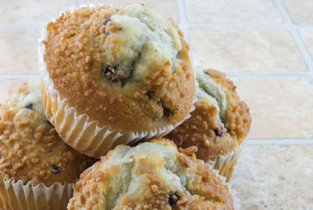 Several blueberry muffins on a stone tile backgroundの写真素材
